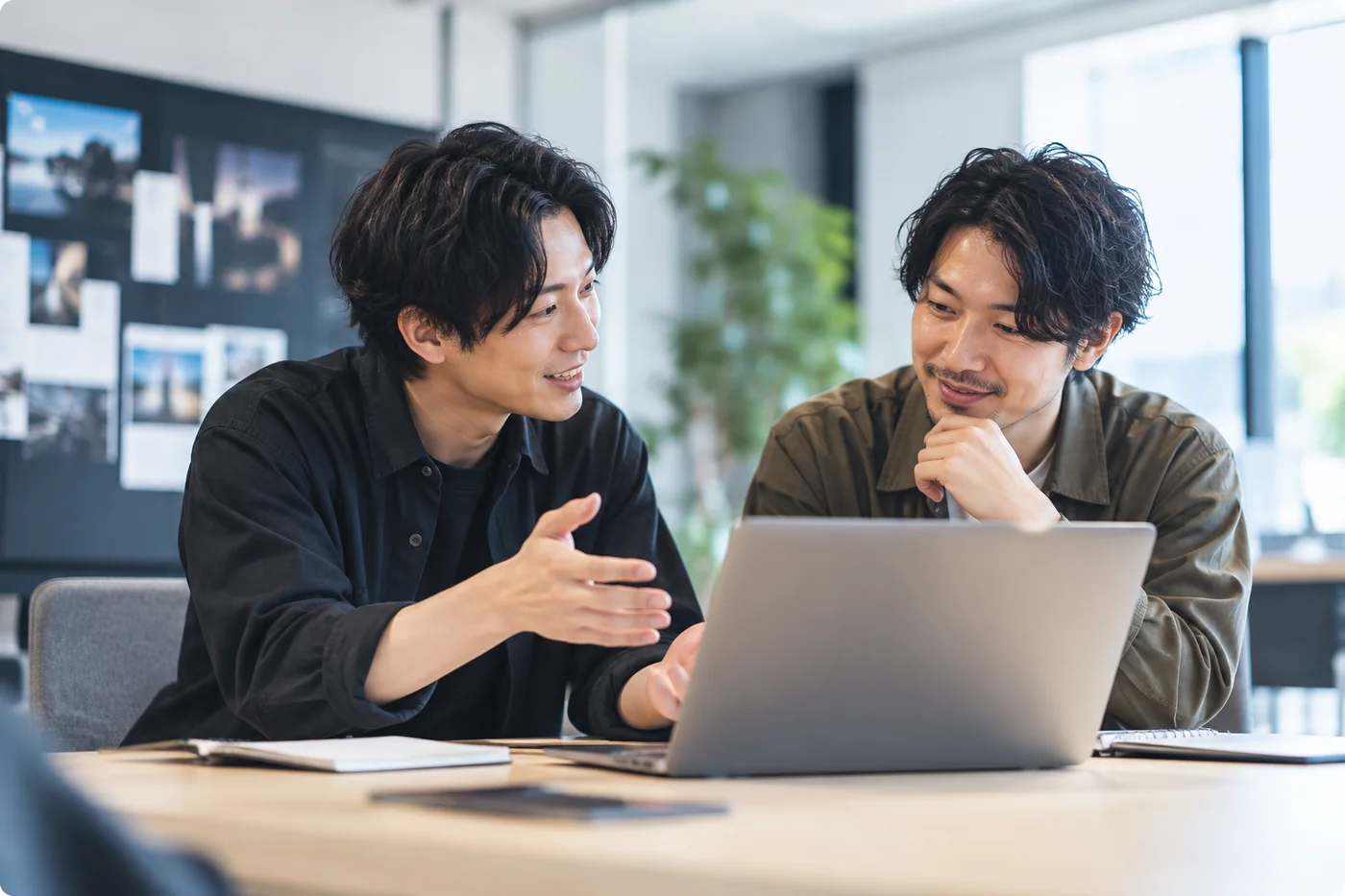 ノートPCを見ながら相談する2人