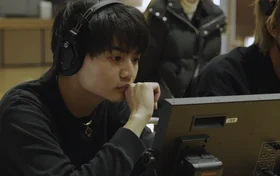 ヘッドホンでモニターを見つめるディレクター