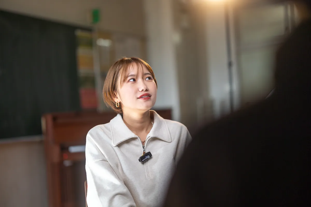 ピンマイクを付けてインタビューに答える女性